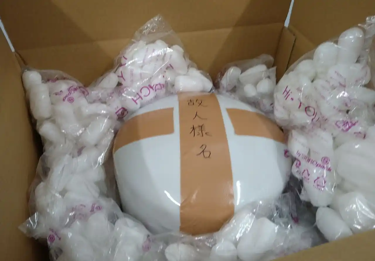 段ボールの内箱へ緩衝材を入れて骨壷を安定させる（ステップ2）